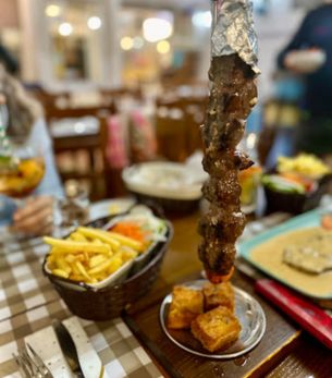 Espetada com batata frita e salada, servida na sala do Restaurante A Toca, em Cacilhas